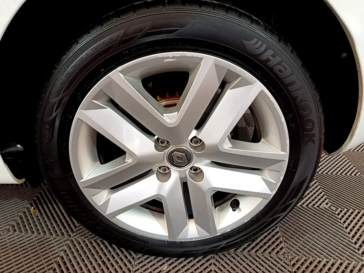 Gros plan sur la roue avant droite blanche d'une Renault Clio Business Blue dCi 85 avec jante alliage à cinq branches.