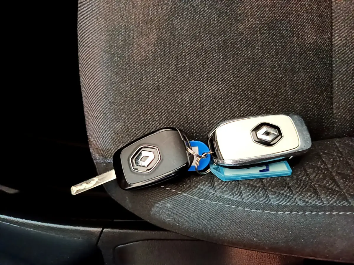 Gros plan sur deux clés Renault posées sur un siège tissu noir à l'intérieur d'une Clio Business Blue dCi 85 blanche.