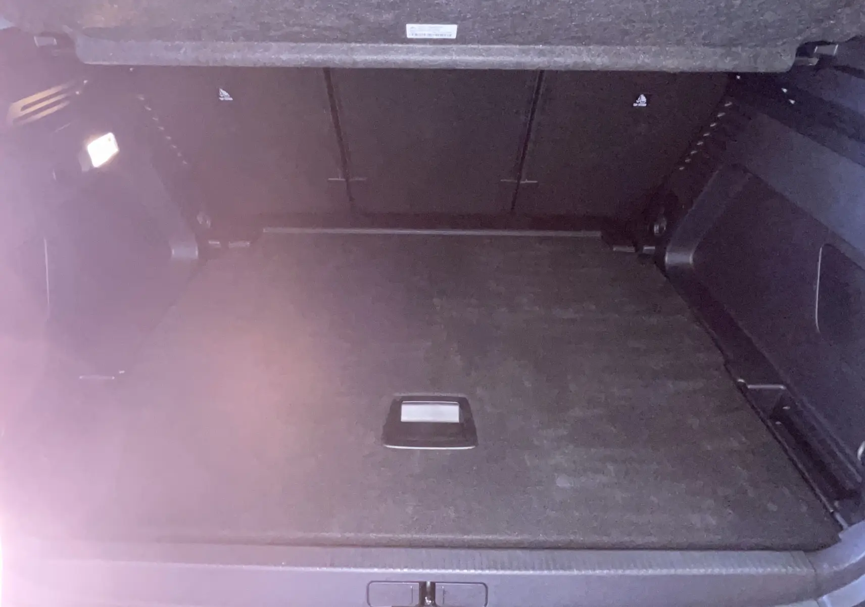 Vue intérieure du coffre spacieux et propre du Citroën C5 Aircross hybride gris platinium, avec éclairage latéral allumé.