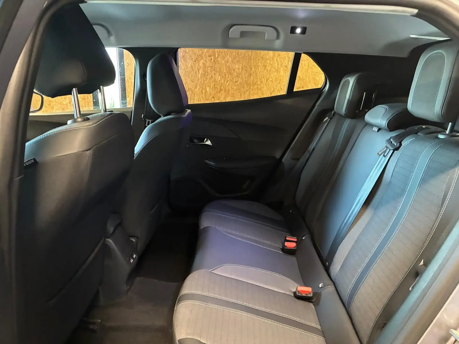Intérieur arrière du Peugeot 2008 gris 2022, vue côté droit montrant les sièges en tissu noir avec appuie-têtes et ceinture de sécurité.