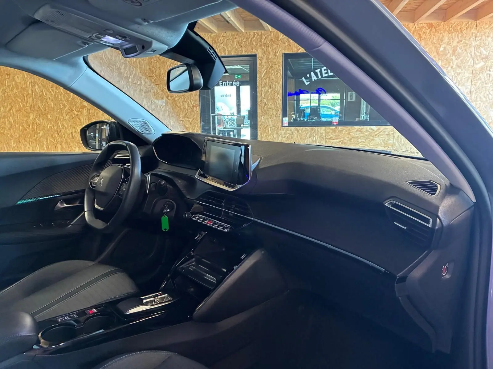 Vue intérieure côté conducteur du Peugeot 2008 gris 2022, mettant en valeur le tableau de bord et l’écran tactile central.