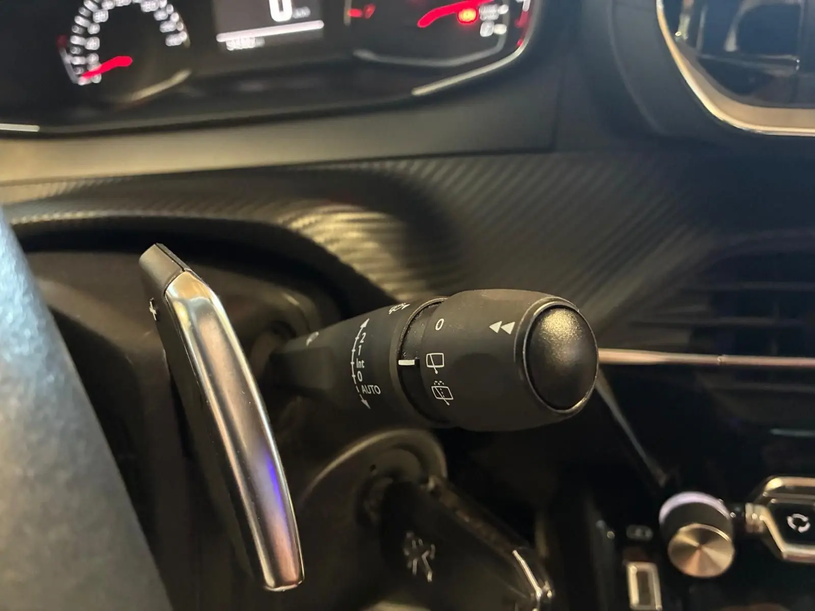 Gros plan sur la manette d’essuie-glace côté gauche du tableau de bord du Peugeot 2008 gris, version 2022.