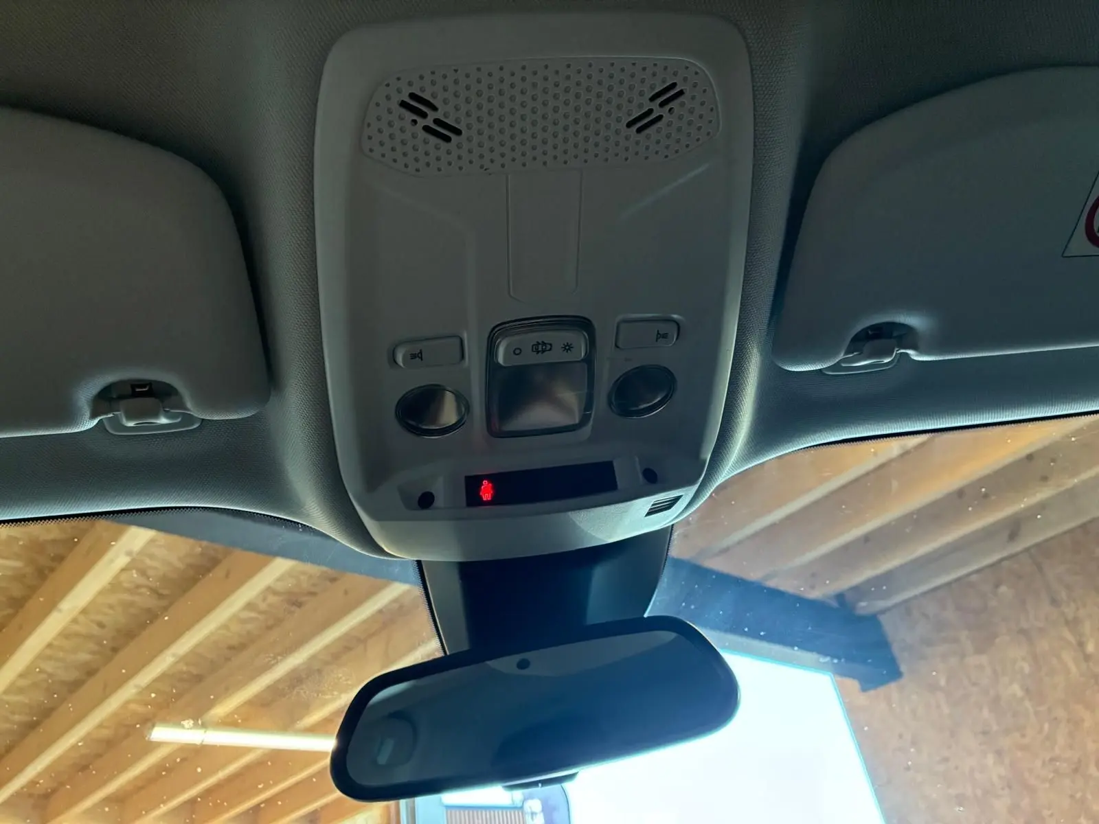 Vue intérieure du plafonnier et du rétroviseur central d’un Peugeot 2008 gris, avec commandes d’éclairage et détecteur.