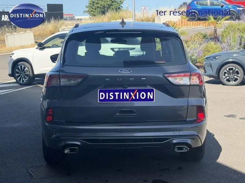 Vue arrière d'un Ford Kuga 2024 gris Solar métallisé avec double sortie d'échappement et feux LED.