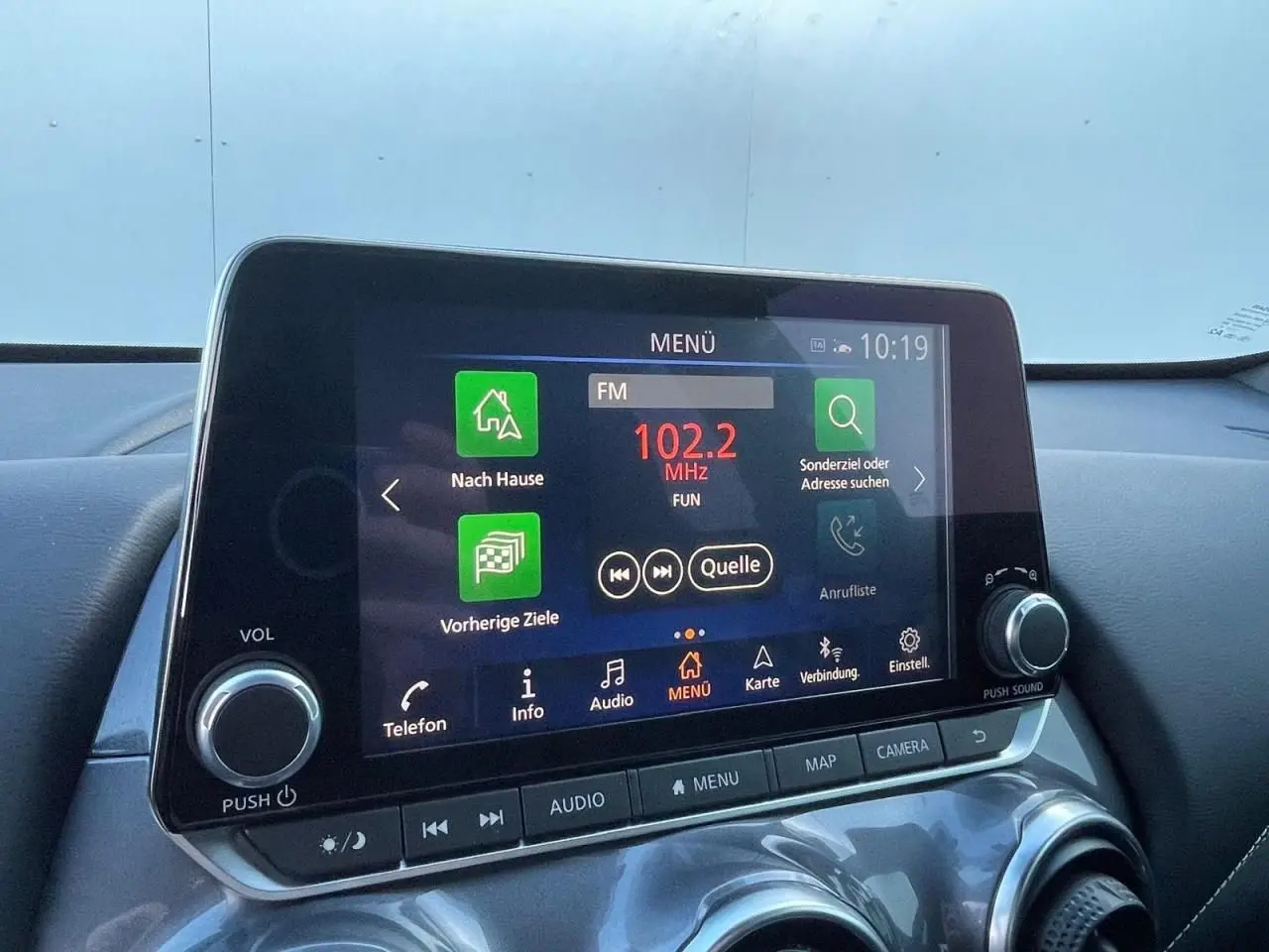 Écran tactile central du Nissan Juke 2024 affichant le menu radio avec commandes autour, intérieur noir.