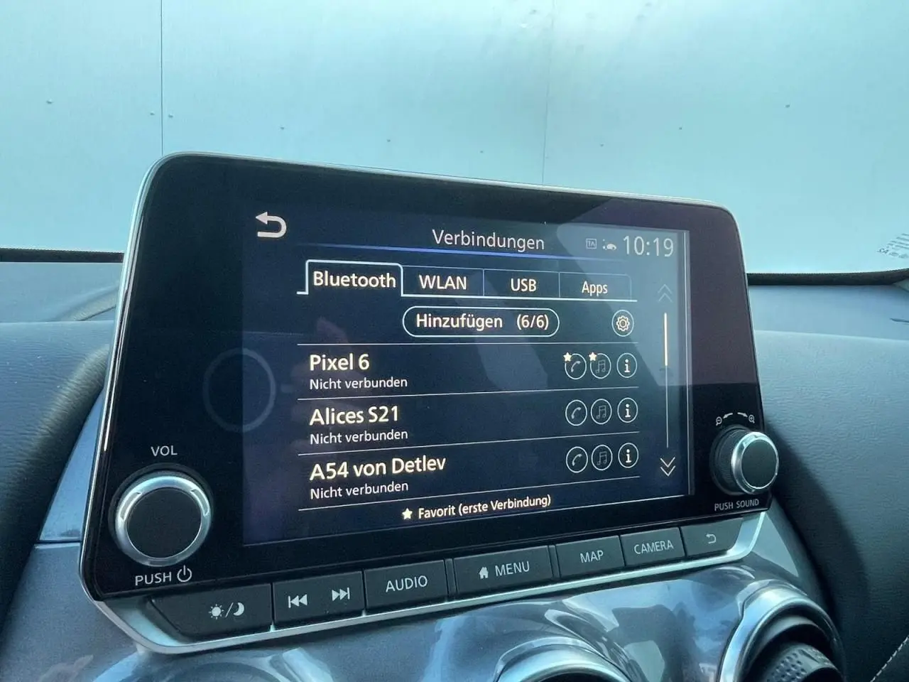 Écran tactile central du Nissan Juke 2024 affichant les options Bluetooth, avec commandes audio et climatisation visibles.