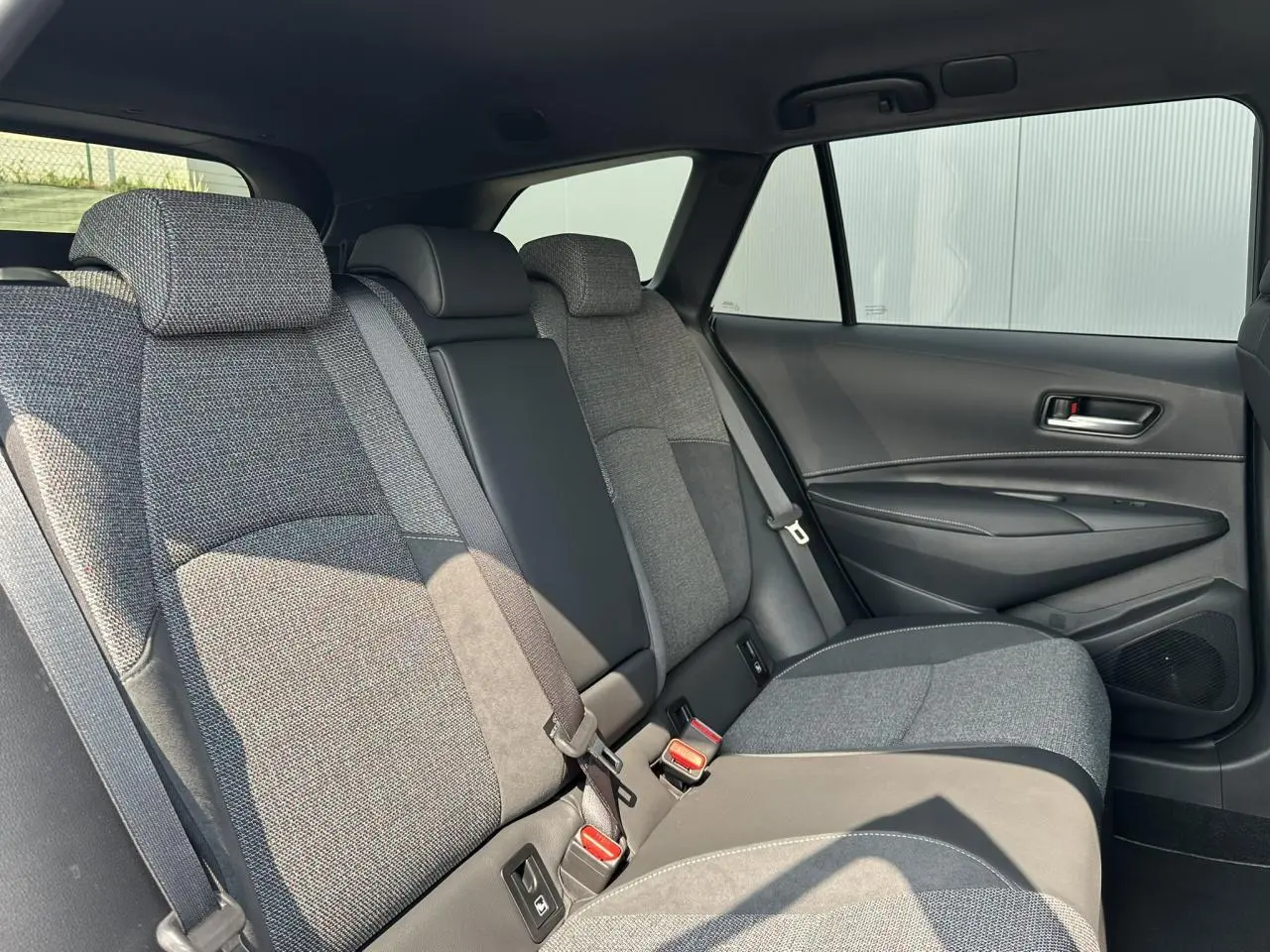 Vue intérieure côté droit des sièges arrière en tissu gris de la Toyota Corolla Touring Sport 2025.