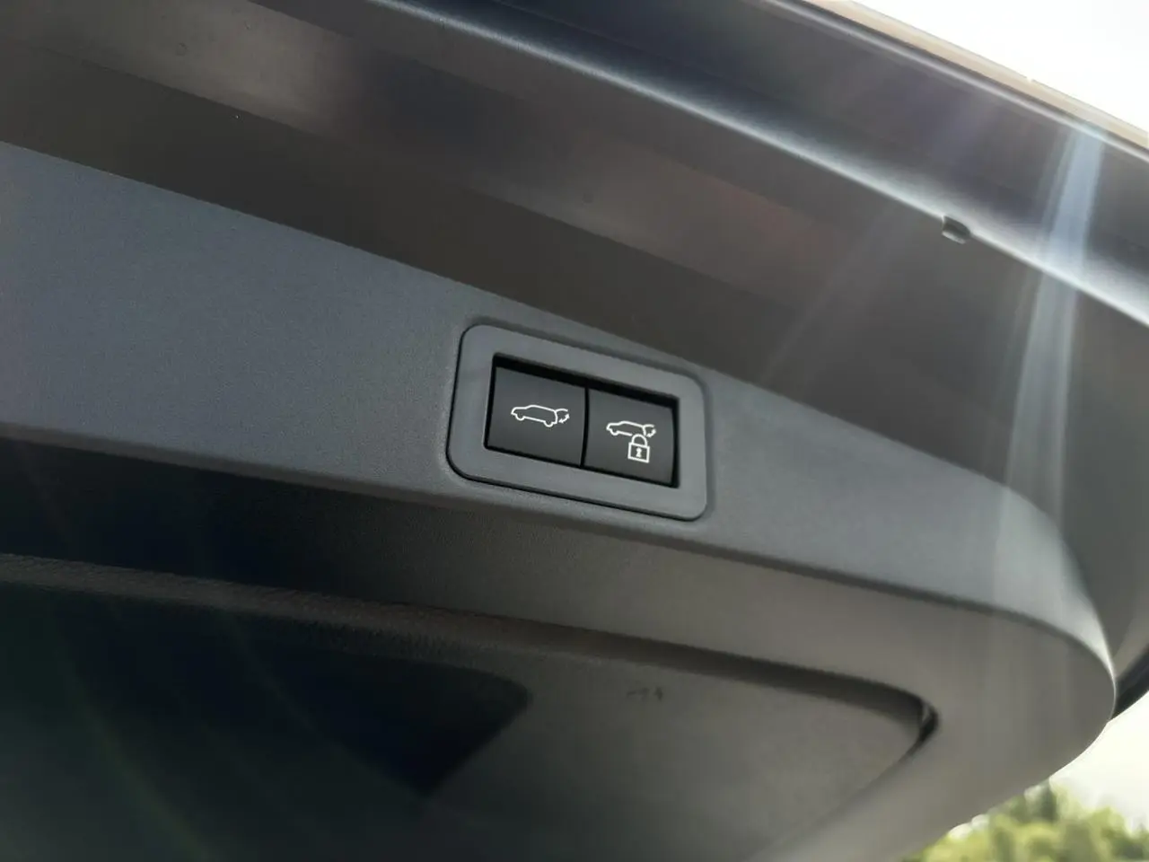 Boutons d'ouverture et de verrouillage électrique du hayon du coffre sur Toyota Corolla Touring Sport blanc.