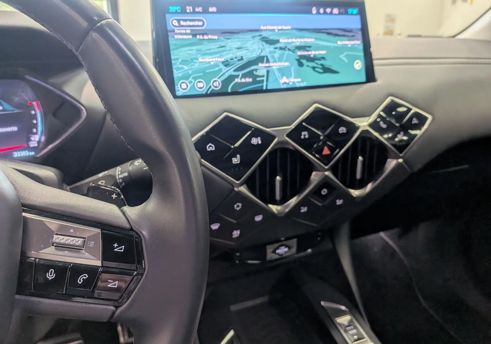 Vue intérieure du tableau de bord du DS3 2024 avec écran tactile GPS et commandes tactiles géométriques sur fond cuir noir.