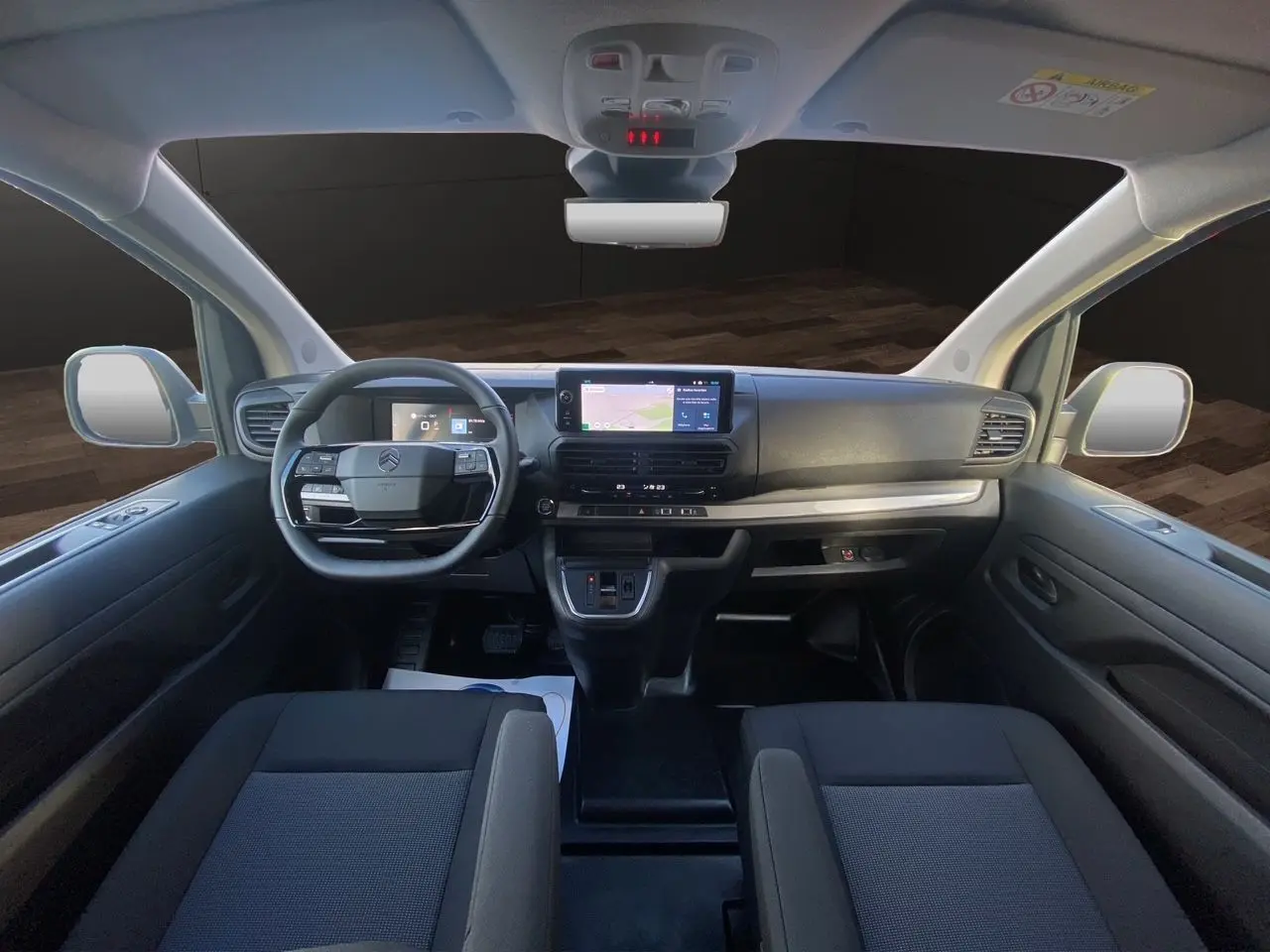 Intérieur avant du Citroën Jumpy XL 2025, tableau de bord moderne avec écran tactile et sièges tissu bi-ton noir-gris.