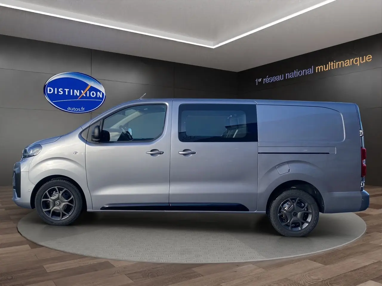 Profil gauche d'un Citroën Jumpy Cabine Approfondie gris acier avec jantes noires et vitres teintées en showroom.