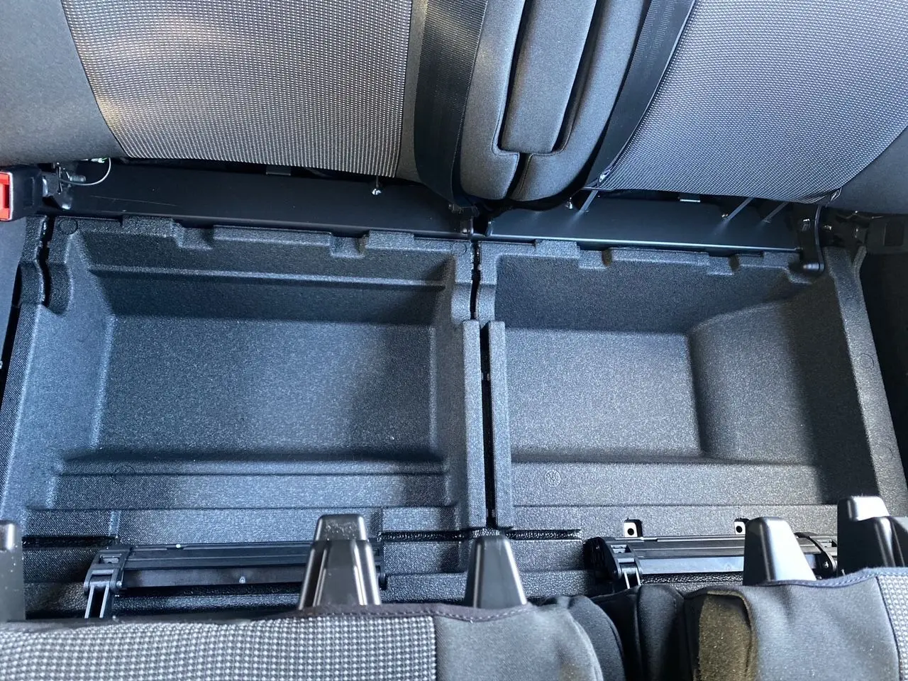 Rangement sous la banquette arrière du Citroën Jumpy Cabine Approfondie gris acier, vue plongeante sur les compartiments ouverts.