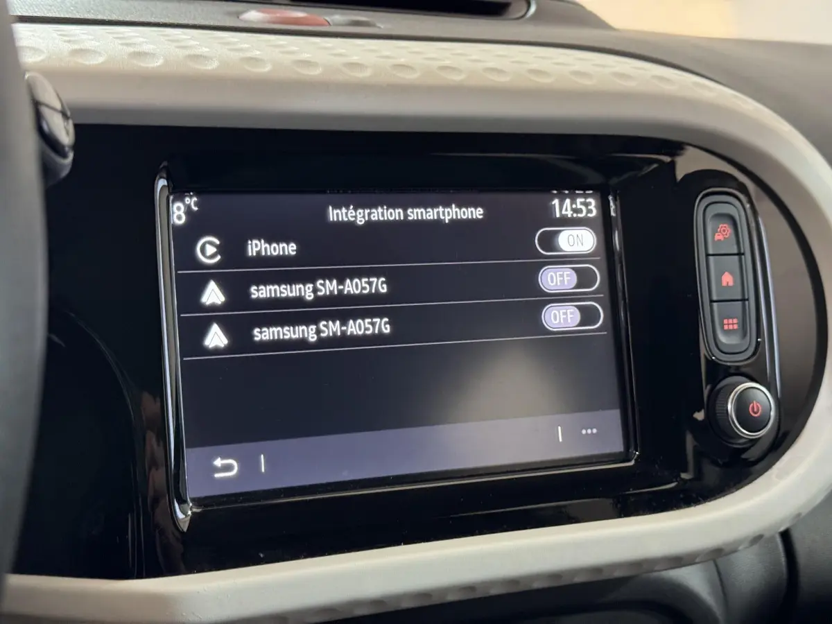 Écran tactile central de la Renault Twingo blanc, affichant l'intégration smartphone avec options iPhone et Samsung.
