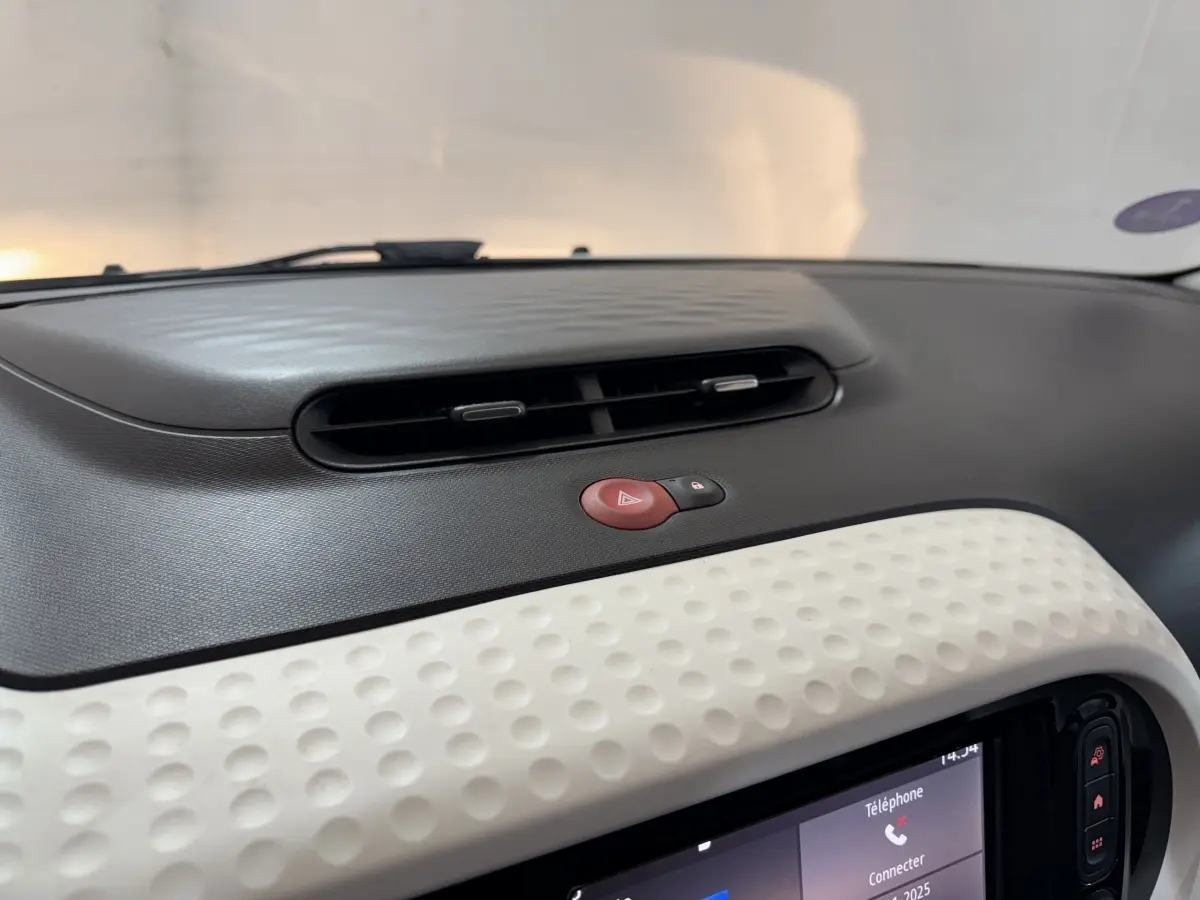 Détail du tableau de bord noir et blanc avec bouton de warning rouge sur Renault Twingo Equilibre 2022.
