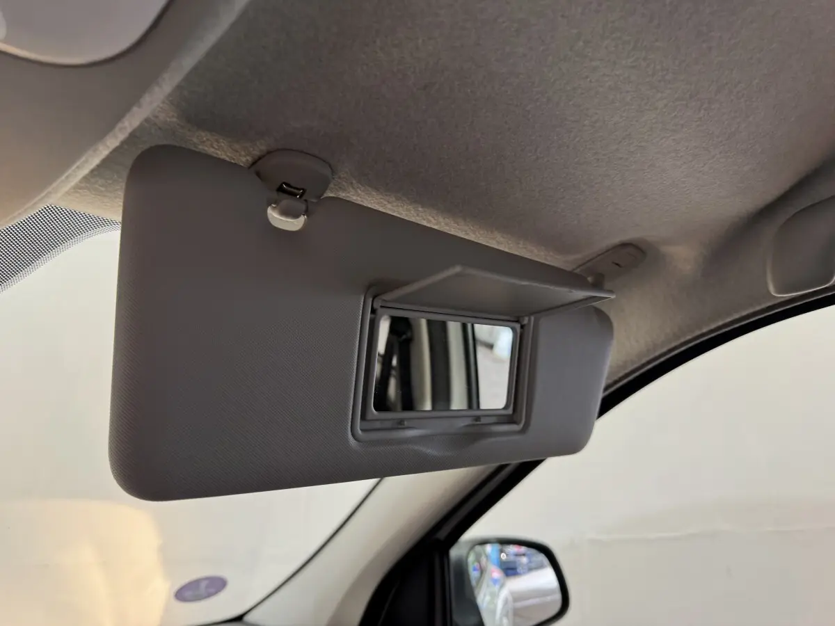 Miroir de courtoisie ouvert sur le pare-soleil côté conducteur de la Renault Twingo blanche, vue intérieure rapprochée.