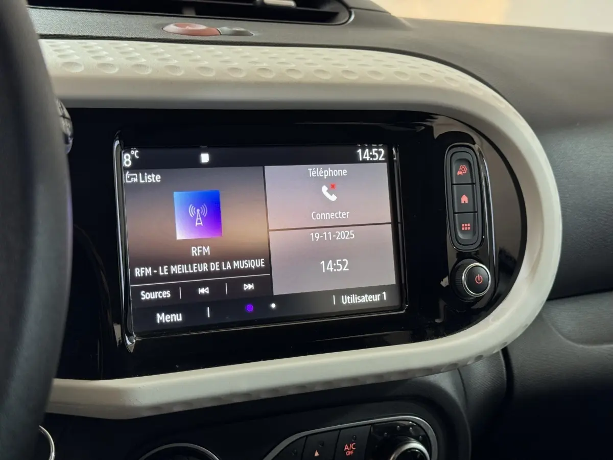 Écran tactile central en gros plan du tableau de bord blanc de la Renault Twingo Equilibre 2022, avec interface multimédia visible.