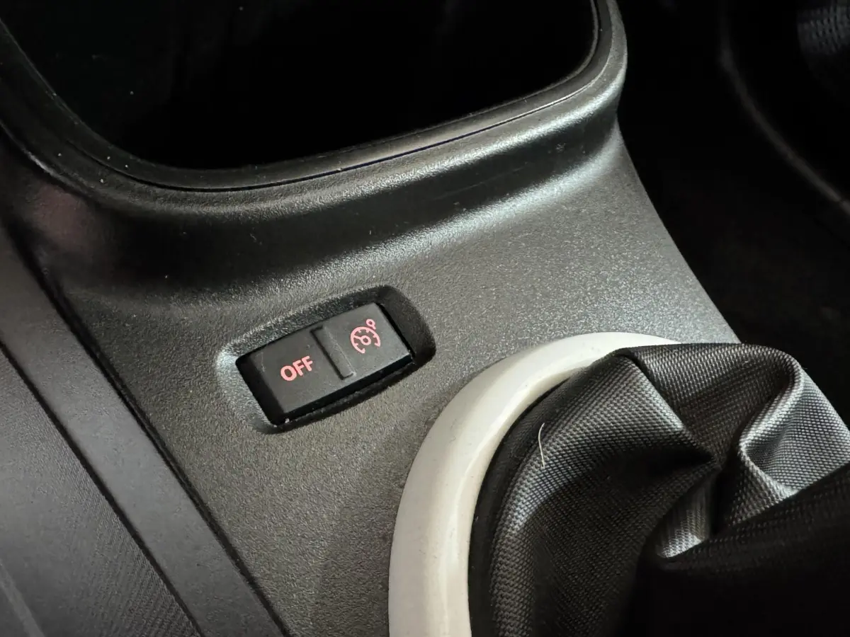 Gros plan sur le bouton de désactivation du régulateur de vitesse près du levier de vitesses d'une Renault Twingo blanche 2022.