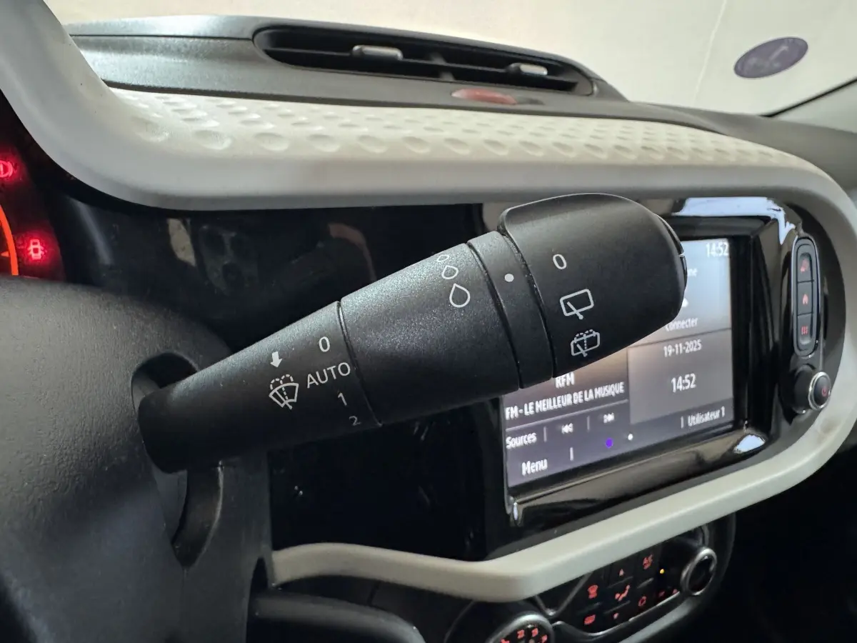 Gros plan sur la commande d'essuie-glace noire dans l'habitacle blanc de la Renault Twingo Equilibre 2022.