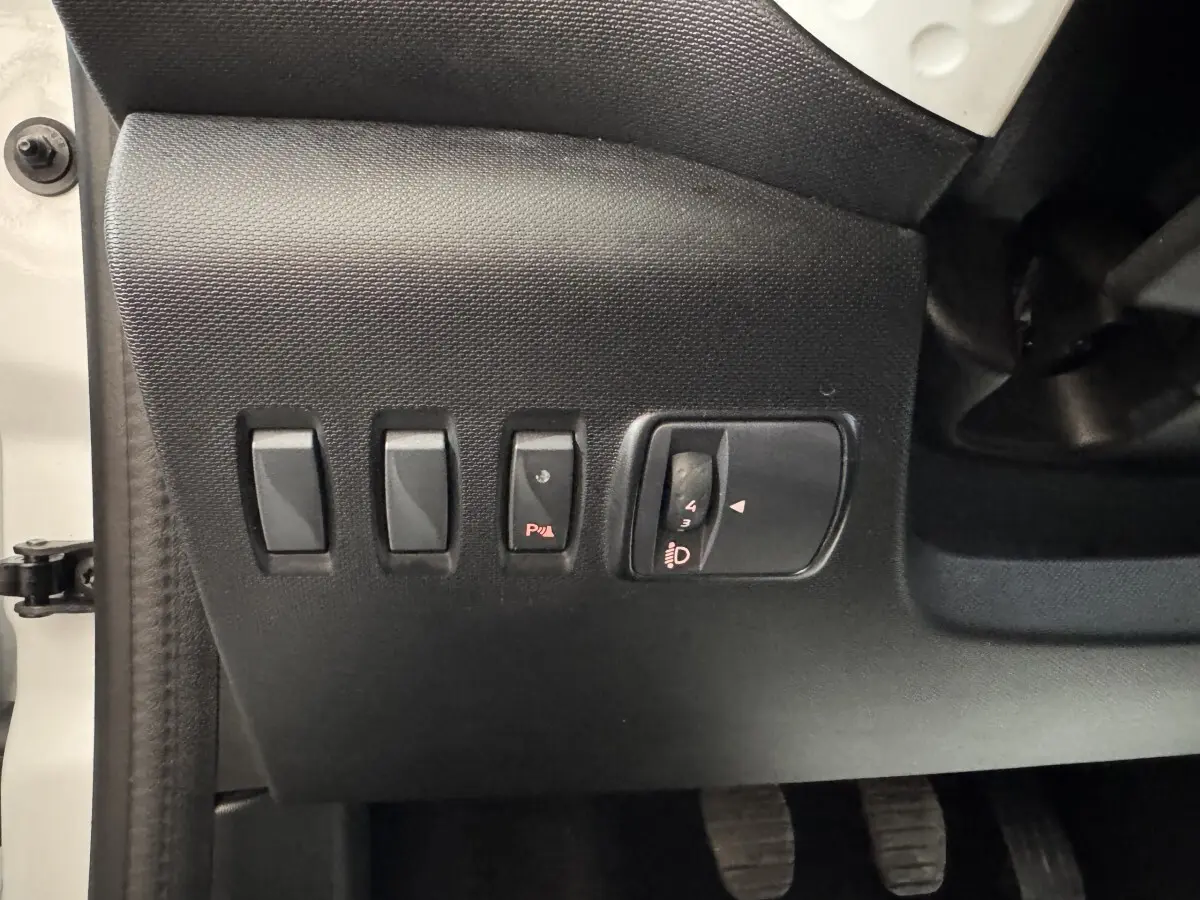 Vue rapprochée des commandes noires côté gauche du tableau de bord d'une Renault Twingo blanche 2022.