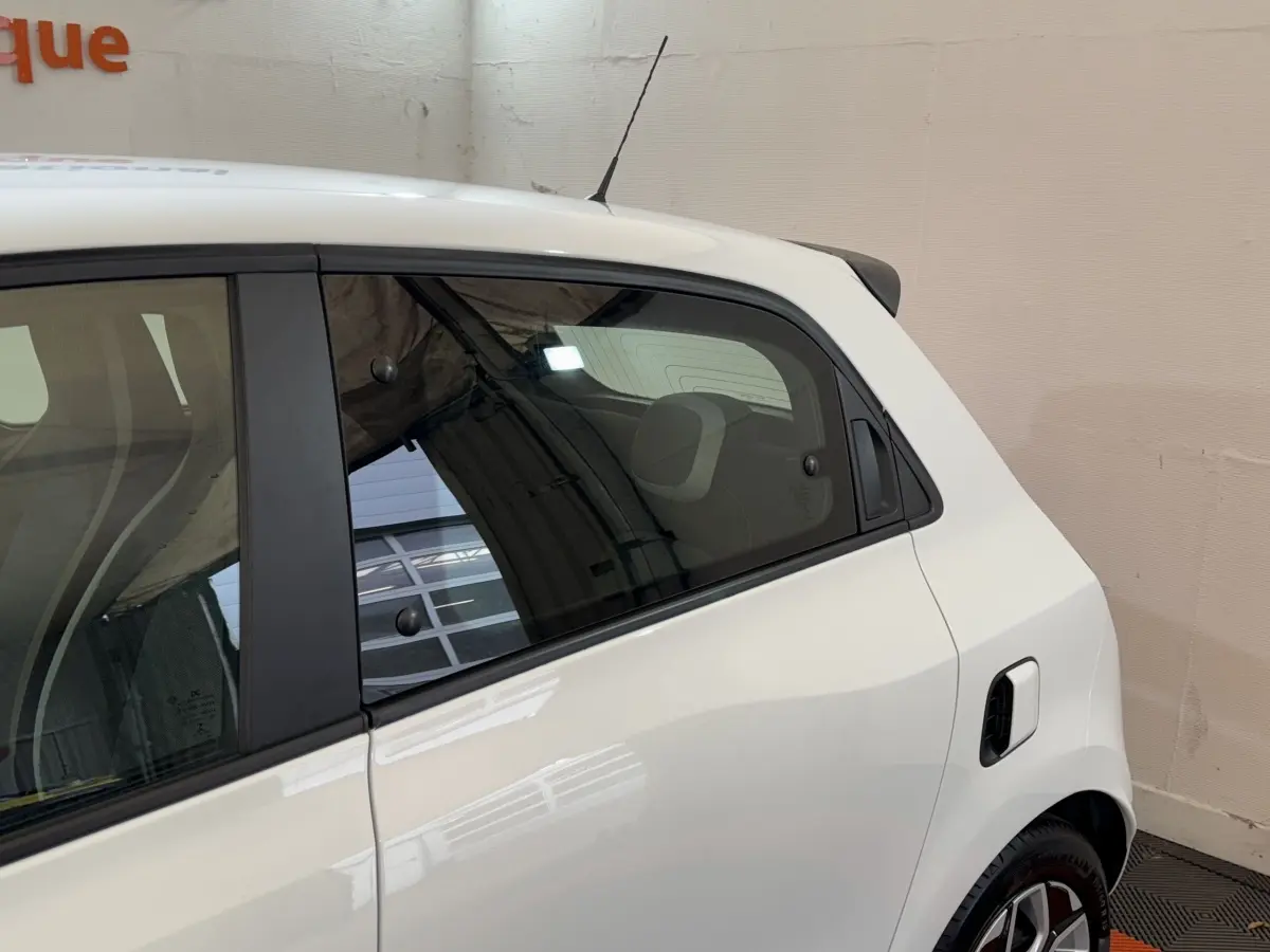 Vue latérale droite sur la partie arrière d'une Renault Twingo blanche avec antenne et jante alliage visible.