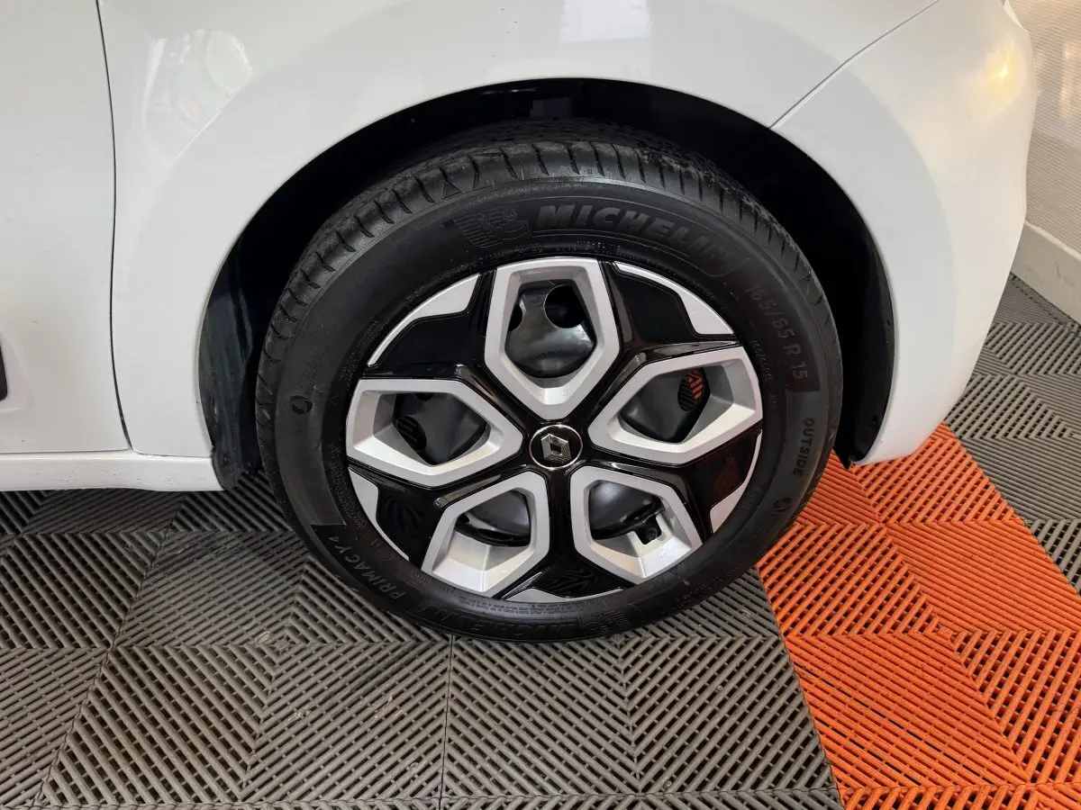 Gros plan sur la roue avant droite blanche d'une Renault Twingo 2022 avec jante en alliage noir et argent.