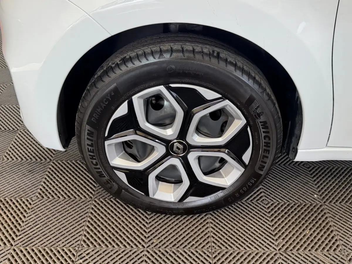 Gros plan sur la roue avant droite blanche d'une Renault Twingo 2022 avec jante en alliage au design moderne.