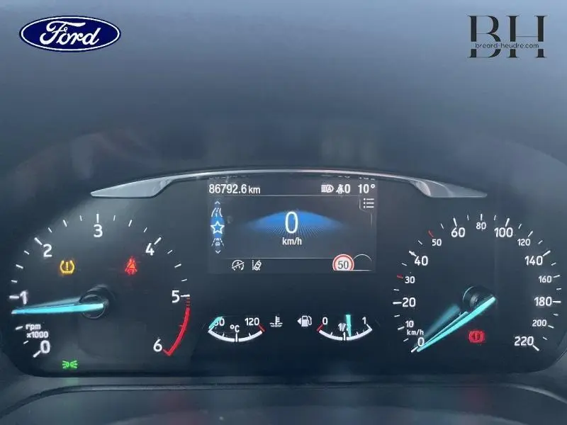 Tableau de bord du Ford Puma blanc Glacier 2020, affichage numérique central et compteurs analogiques éclairés.