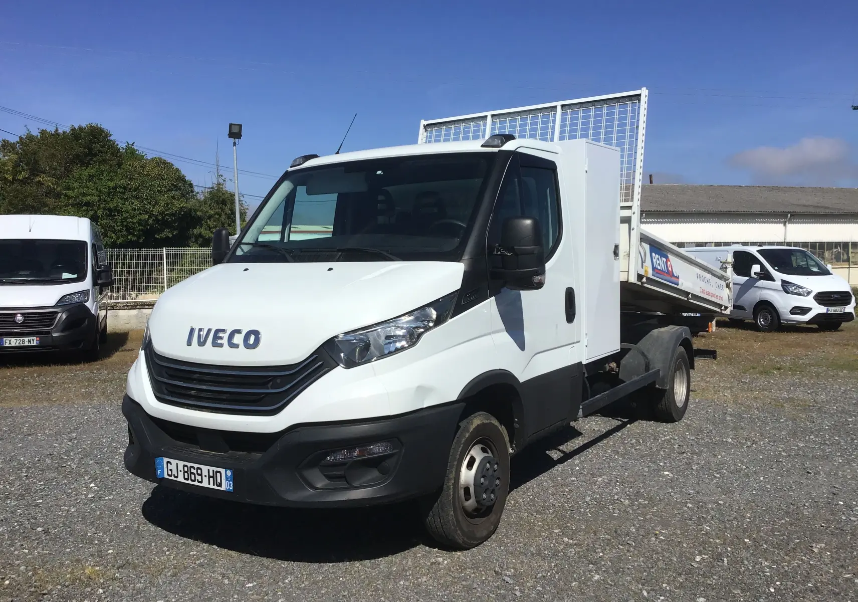 IVECO Daily Chassis Cabine blanc en 3/4 avant droit avec benne acier et coffre latéral visible.