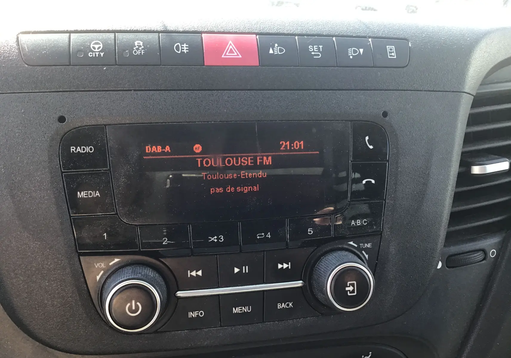 Gros plan sur la console centrale noire de l’Iveco Daily 2022, affichant la radio Toulouse FM en mode DAB-A.