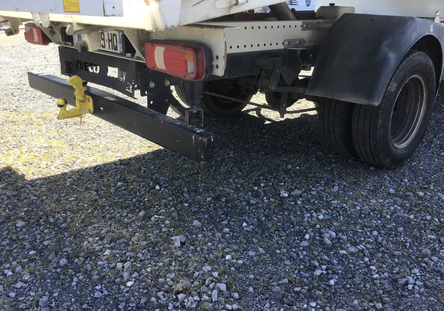 Vue arrière droite d’un Iveco Daily Chassis Cabine blanc 2022 avec benne JPM en acier et attelage jaune visible.