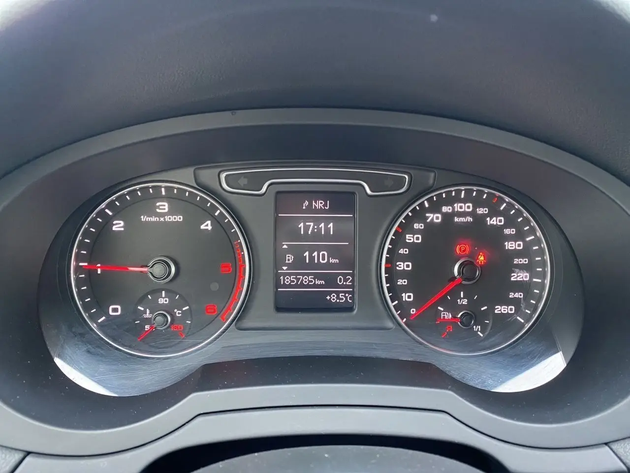 Vue rapprochée du tableau de bord noir de l'Audi Q3 2.0 TDI 2014 avec compteur et écran digital central.
