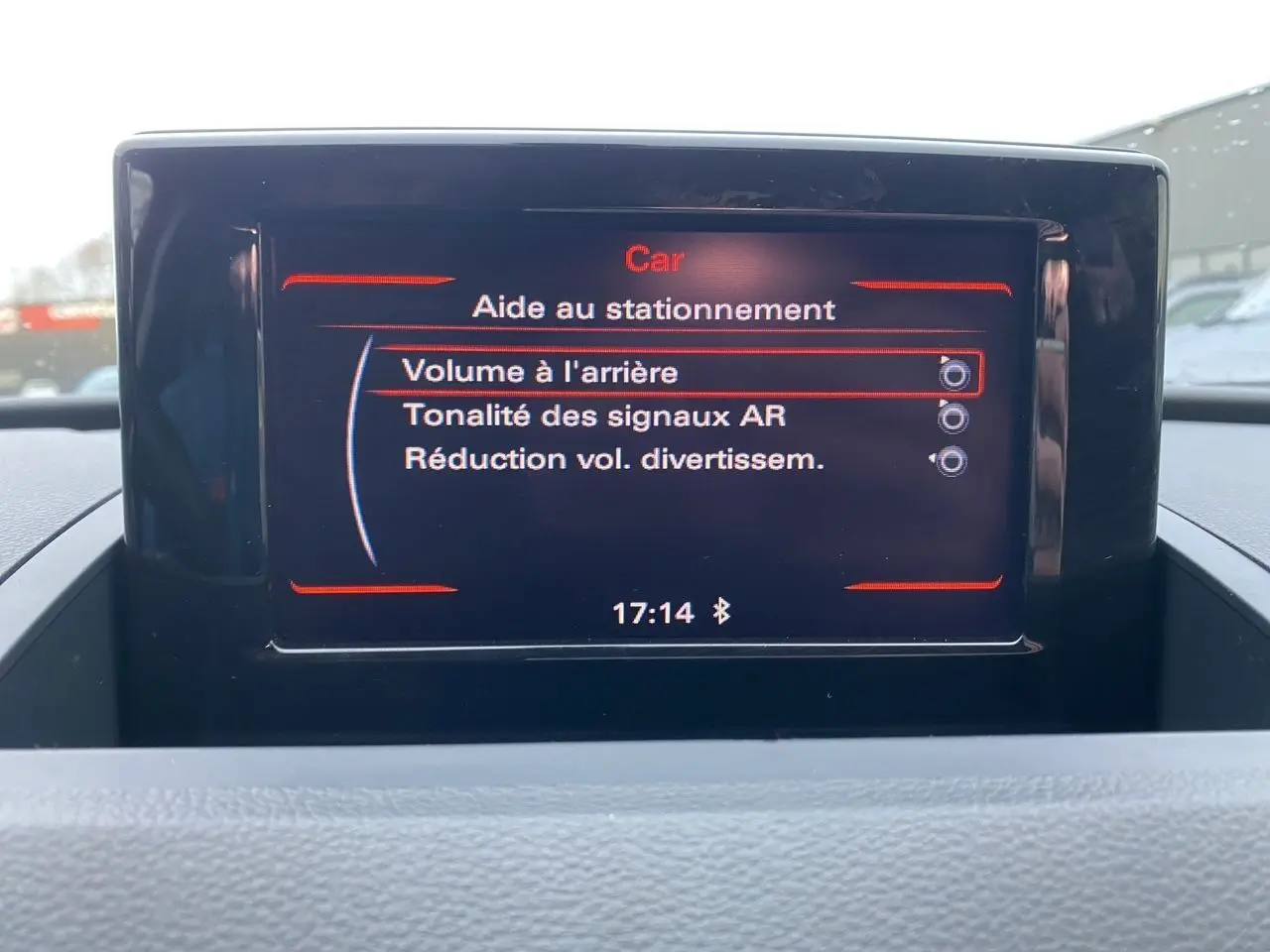 Écran GPS intérieur de l'Audi Q3 blanc de 2014 affichant les options d'aide au stationnement.