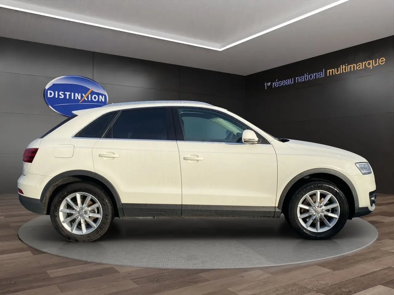 Audi Q3 blanc vue de profil côté gauche, vitres arrière surteintées et jantes alliage 17 pouces.