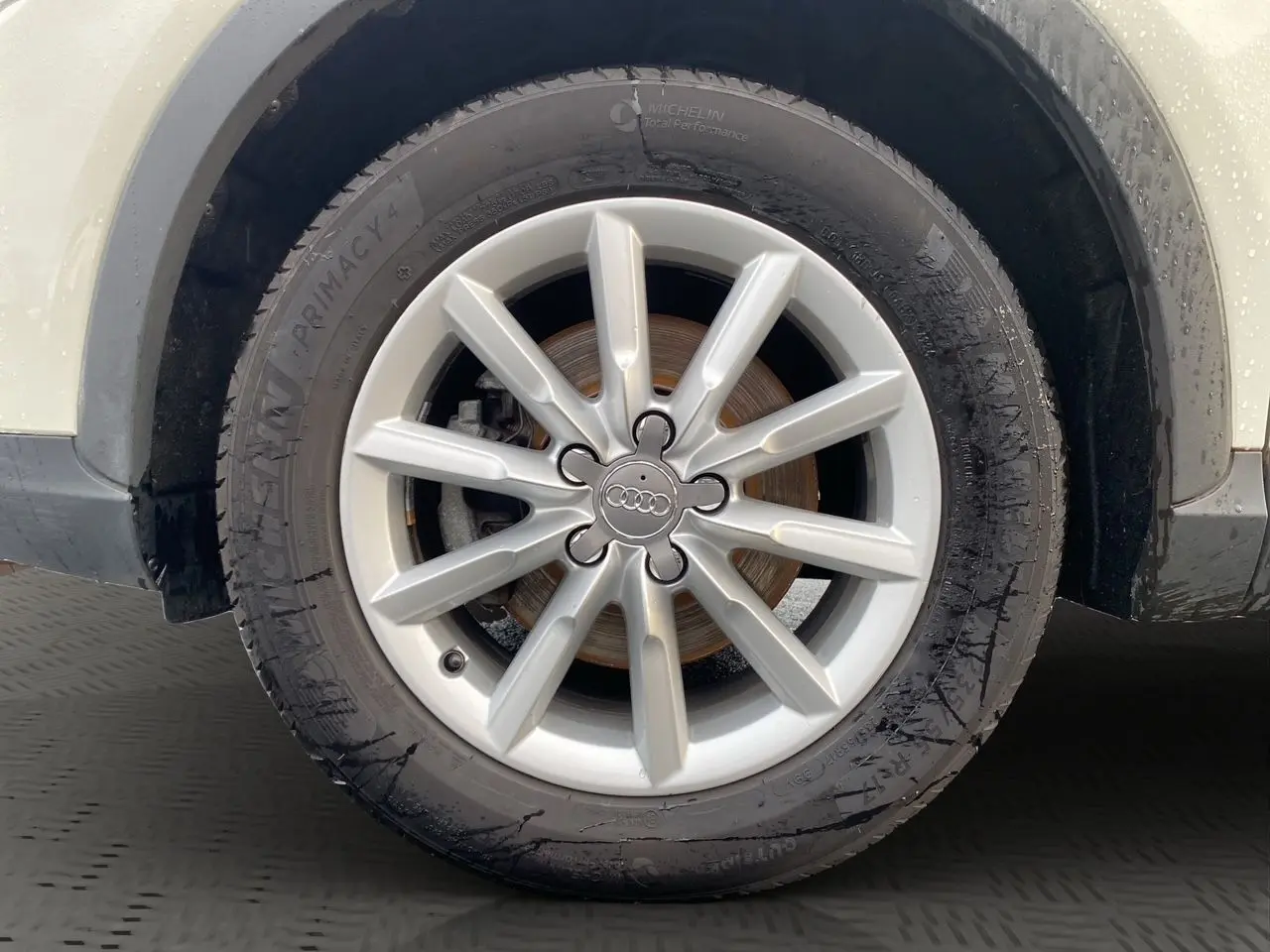 Gros plan sur la roue avant droite blanche d’un Audi Q3 2.0 TDI avec jante argentée à 10 branches.