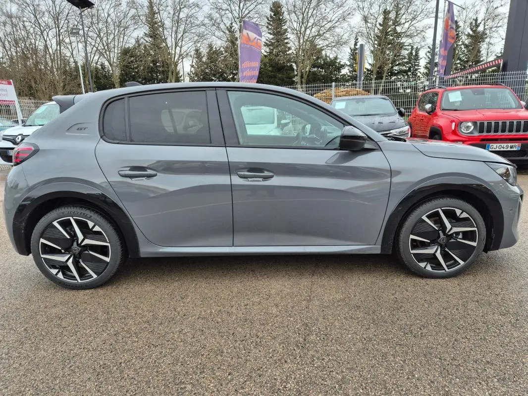 Profil côté droit d'une Peugeot 208 Hybrid 110 e-DCS6 GT gris avec jantes alliage 17 pouces et badge GT visible à l'arrière.