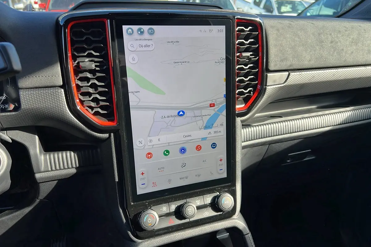 Vue rapprochée de la console centrale avec écran tactile vertical et aérateurs rouges du Ford Ranger Raptor noir.