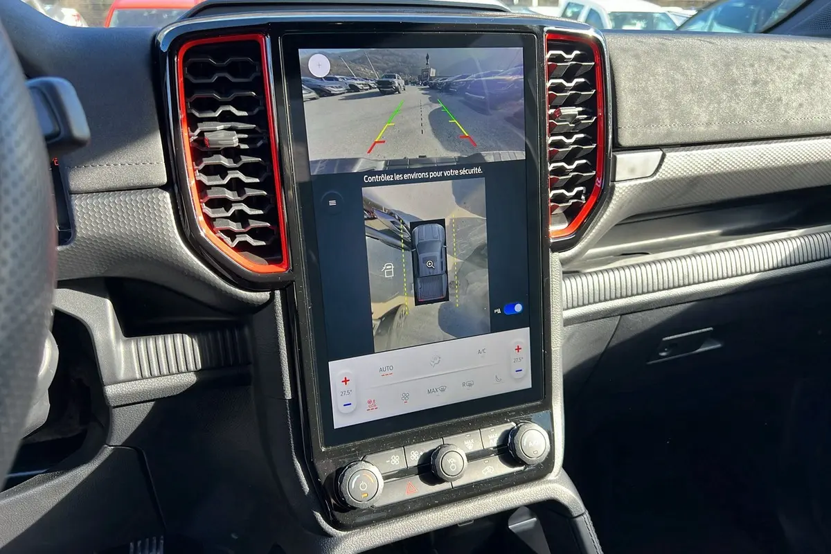 Vue rapprochée de la console centrale du Ford Ranger Raptor 2025 avec écran tactile affichant caméra 360°, entouré de détails rouges.