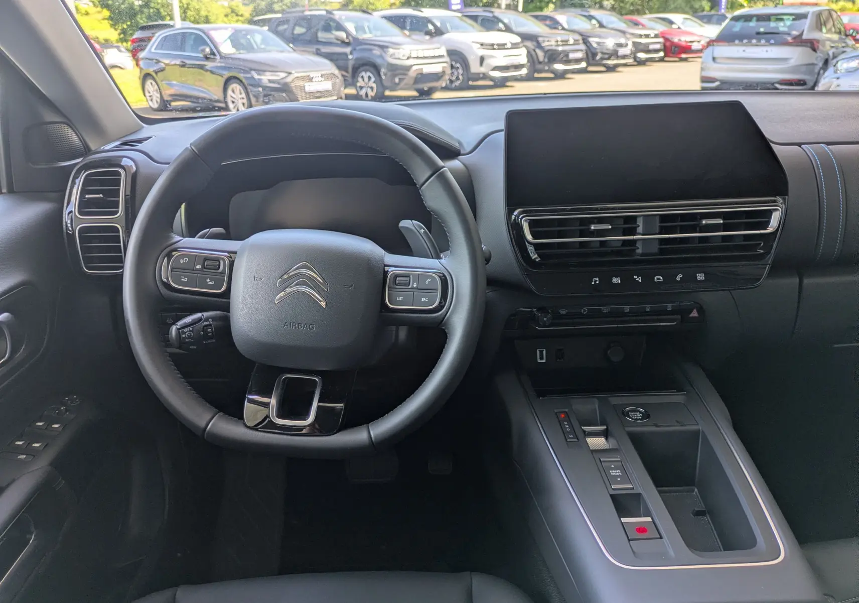Vue intérieure centrée sur le volant et la console centrale du Citroën C5 Aircross noir Perla, avec écran tactile et commandes intégrées.