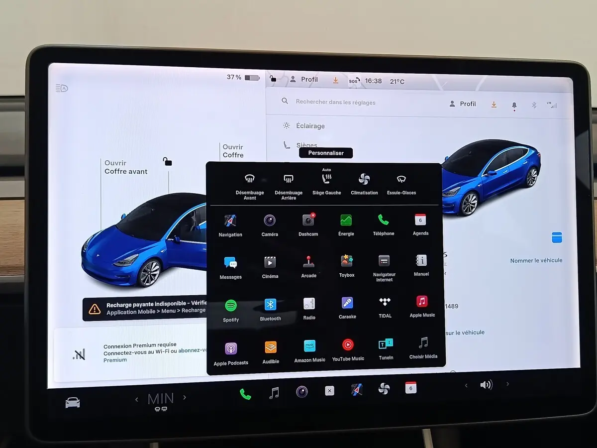 Écran tactile central affichant les réglages et une vue 3/4 avant d'une Tesla Model 3 bleu électrique.