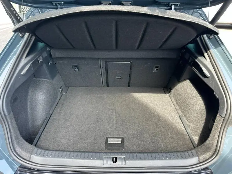 Coffre ouvert vu de face d'un CUPRA Formentor bleu, montrant un espace de chargement propre et bien fini.