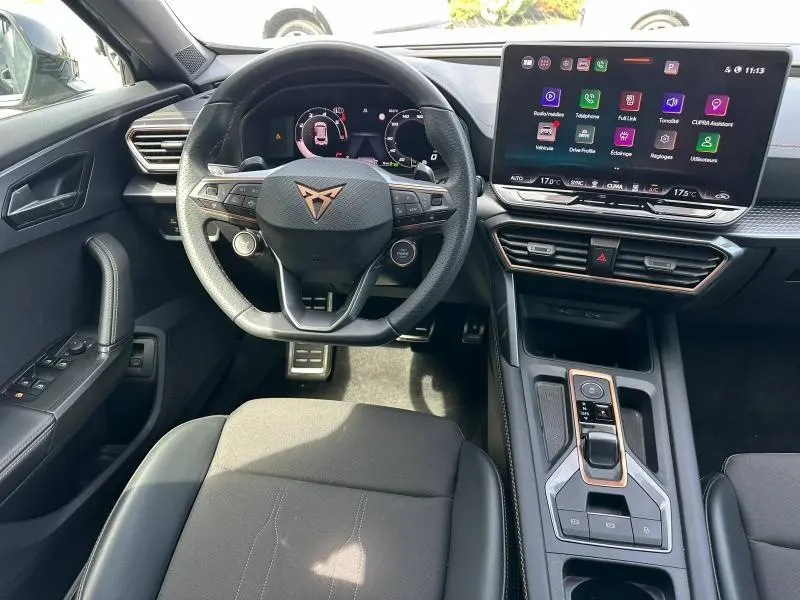Vue intérieure avant centrée sur le volant cuir noir avec logo CUPRA et écran tactile du tableau de bord du Formentor 2025.