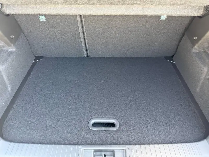 Vue du coffre ouvert du Renault Captur 1.8 E-Tech 2026, montrant le plancher de coffre plat et recouvert.