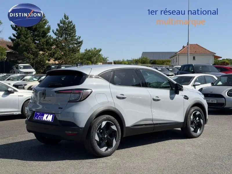Vue 3/4 arrière droite d'un Renault Captur gris Rafale métallisé avec jantes noires et toit noir, stationné en extérieur.