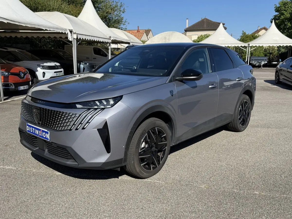 Peugeot 3008 gris clair en 3/4 avant droit, avec calandre noire distinctive et jantes alliage noires.