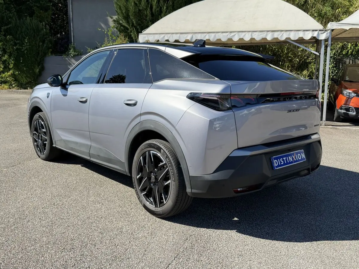 Peugeot 3008 gris clair vue 3/4 avant droit, avec calandre distinctive et jantes noires stylisées.