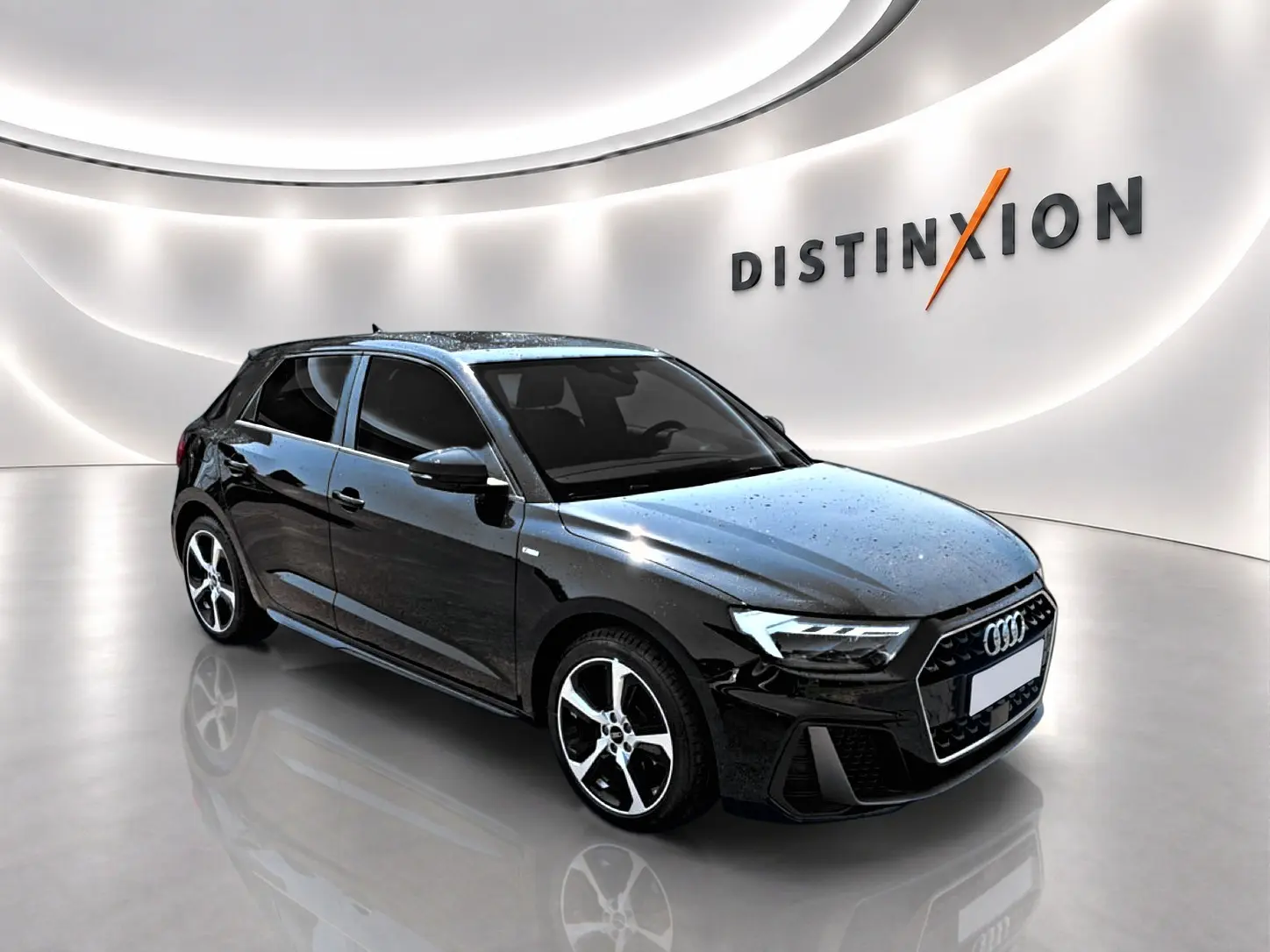 Audi A1 Sportback noir vue 3/4 avant droit avec jantes alliage et phares LED dans un showroom lumineux.