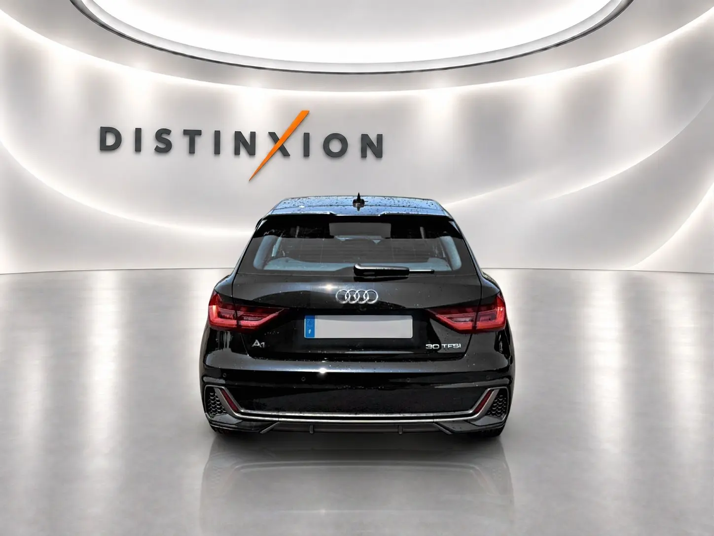 Vue arrière d'une Audi A1 Sportback noire 30 TFSI S line 2026 avec feux LED et becquet arrière en showroom.