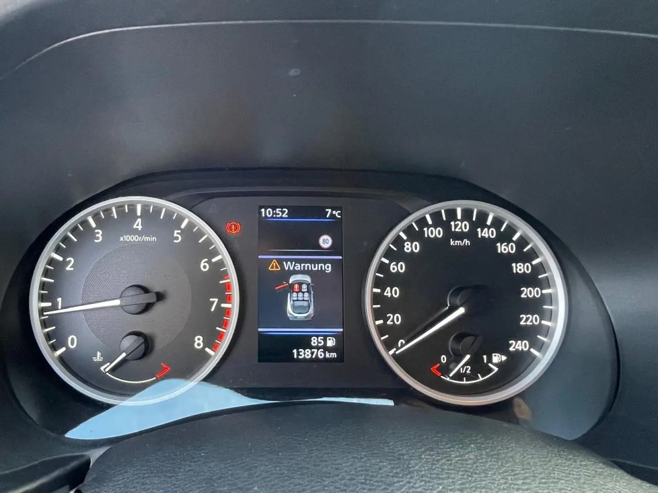 Combiné d'instruments digital du Nissan Juke 2024 avec compte-tours, vitesse et affichage d'alerte en tableau de bord.