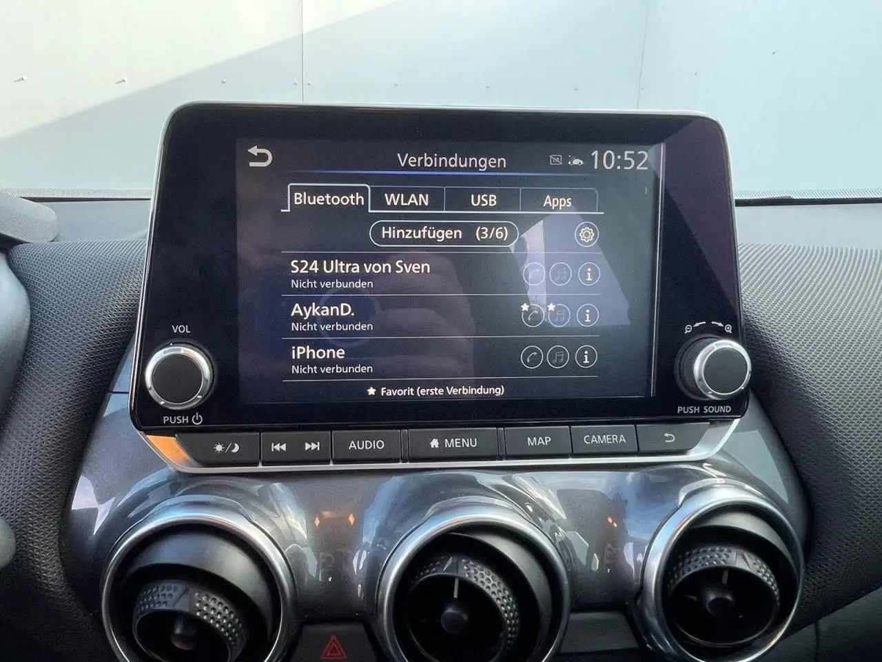 Écran tactile central du Nissan Juke II 2024 avec commandes audio et climatisation, finition gris céramic.