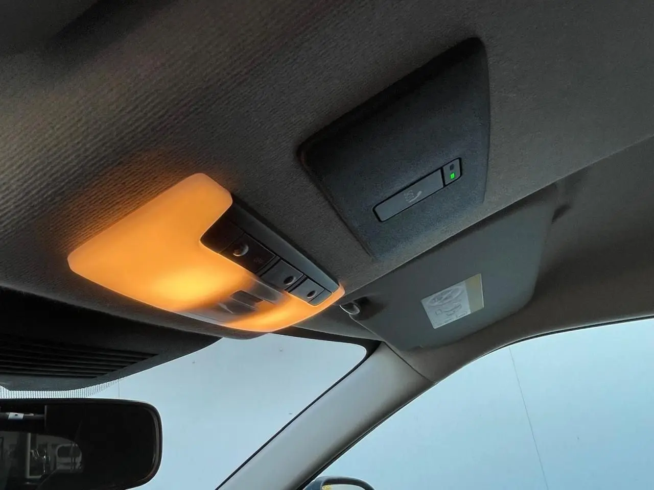 Plafonnier intérieur allumé avec capteur et pare-soleil côté conducteur d'un Nissan Juke II gris ceramic 2024